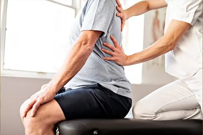Kinésithérapeute effectuant un soin manuel dans le dos d’un patient